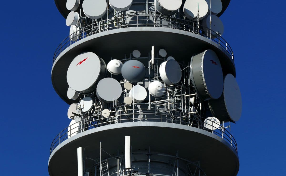 Cellular communications tower against a clear sky